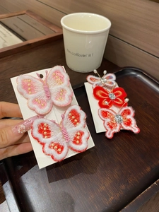 Détail de pinces à cheveux papillon brodées avec pompons et perles pour style Hanfu