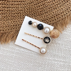 Détail d'un lot de 3 barrettes à cheveux avec perles et motifs couronne sur support