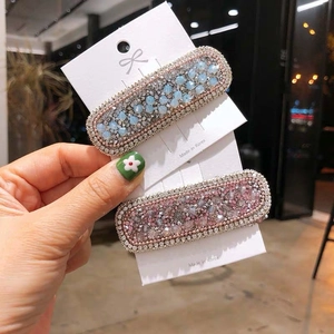 Set of two crystal beaded hair clips in light blue and pink on a white card display