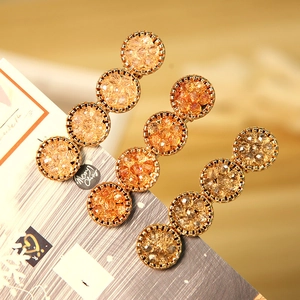 Set de barrettes à cheveux en strass ambre et métal doré sur carte de présentation