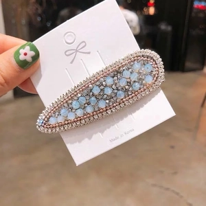 Détail d'une pince à cheveux goutte coréenne avec perles bleues mates et strass brillants