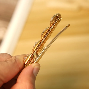 Barrette à cheveux élégante en métal doré avec quatre perles rose orangé brillantes pour femme