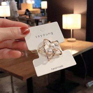 Vue détaillée d'une barrette dorée en forme d'étoile avec perles élégantes et strass brillants