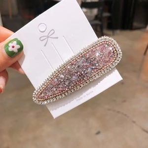 Détail de la pince à cheveux avec cristaux roses et clairs sur carte de présentation