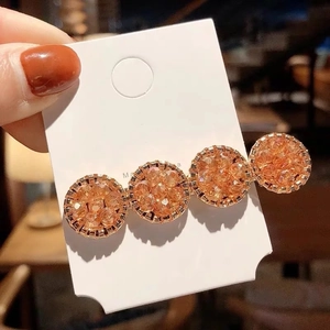 Détail de la barrette en cristal ambré avec quatre strass ronds sur carte blanche
