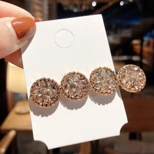Détail macro de quatre strass champagne sur une barrette à cheveux en or rose
