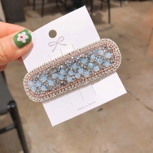 Detailed view of handmade light blue beaded hair clip with silver rhinestone embellishments