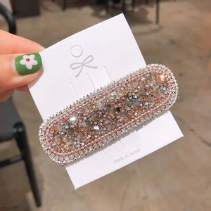 Detailed close-up of crystal BB hair clip with sparkling rhinestones on white card