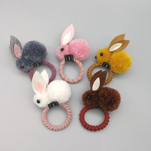 Détail de cinq chouchous lapin en peluche colorés avec des bandes élastiques tissées
