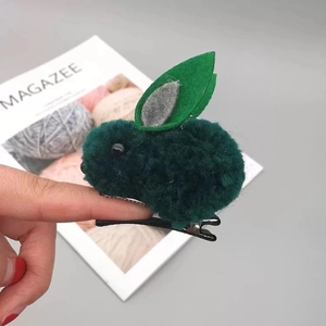 Détail de la barrette à cheveux oreilles de lapin en peluche vert foncé avec accents de feutre
