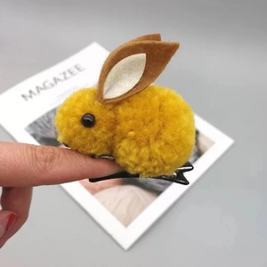 Détail d'une pince à cheveux lapin en peluche jaune avec oreilles en feutre et clip en métal