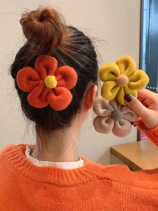 Chic floral plush hair clips in orange and beige for women, shown on hair and hand