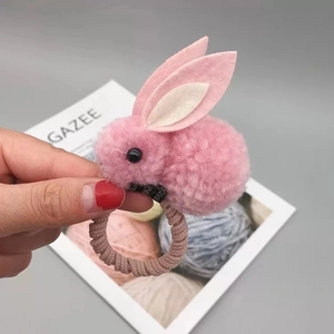 Détail d'un chouchou lapin en peluche rose avec corde élastique spirale pour enfants
