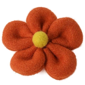 Handmade orange wool felt flower hair clip with yellow center on white background
