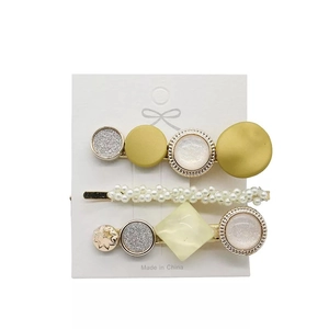 Detailliertes Set aus drei eleganten Haarklammern mit Perlen und Harz auf weißer Karte