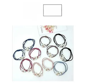 Detail of 10-piece elastic hair tie set featuring artificial pearls and gold beads