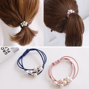 Detail of high-elasticity hair ties with white imitation pearls and rose gold metal beads