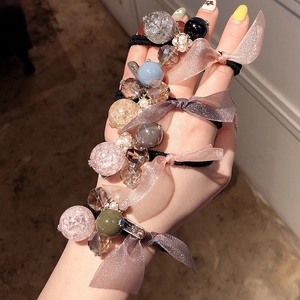 Élastiques à cheveux avec perles et nœuds en satin portés au poignet pour femme