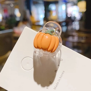 Gros plan d'une pince à cheveux citrouille en résine sur carte de présentation Halloween