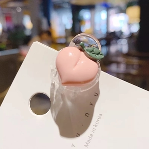 Gros plan d'une mini pince à cheveux en forme de pêche rose avec une feuille verte