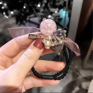 Détail de l'élastique à cheveux coréen avec nœud violet, perle rose et perles blanches