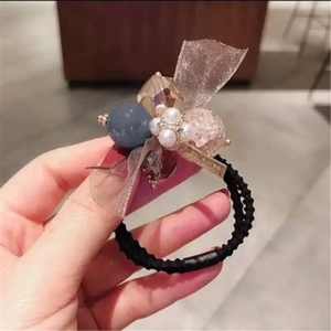 Gros plan sur un chouchou fait main avec des perles, des billes et des mailles en dentelle
