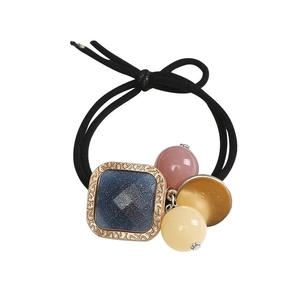 Élastique à cheveux avec pendentif carré bleu pailleté et perles sur fond blanc