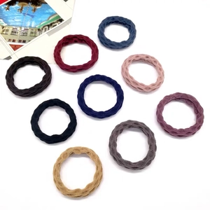 Detail of nine seamless thick elastic hair ties in various colors with woven texture