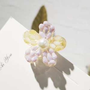 Rainbow crystal flower hair claw with purple and yellow beads and a white pearl center