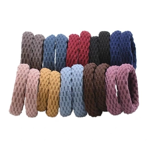 Close-up of thick seamless hair ties showing elastic honeycomb knit texture in multiple colors