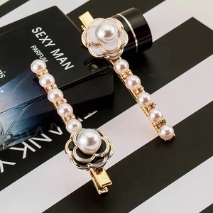 Close-up of elegant camellia hair clips with lustrous pearls and sparkling rhinestones