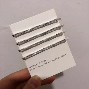 Detailed view of four silver rhinestone hair clips set on white display cardboard