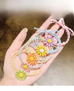 Nahaufnahme bunter Gänseblümchen-Haargummis mit elastischen Bändern und Blumenanhängern