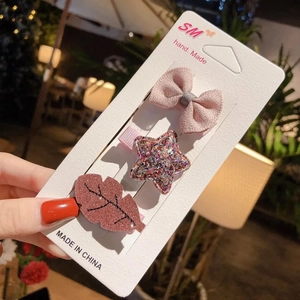 Detailed set of bow and glitter star hair clips on display card for toddlers