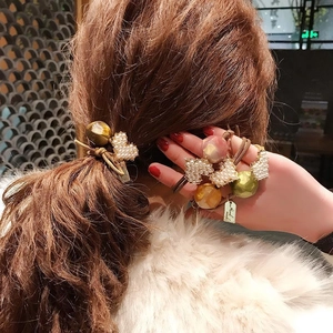 Elastic hair tie set with colorful resin beads and pearl heart charm on brown wavy hair