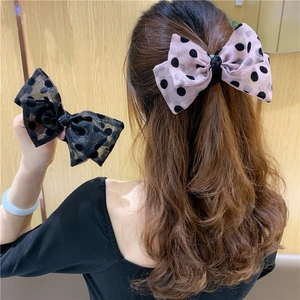 Detail of elegant polka dot bow hair clips in black and light pink tulle fabric