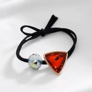 Detailed view of elastic hair tie with red triangle crystal and transparent bead decoration