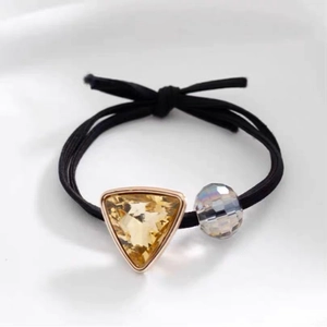 Detail of high-elasticity black hair tie with champagne crystal and iridescent round bead