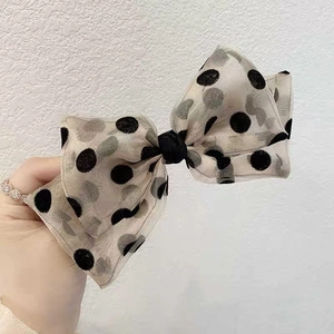 Detailed view of oversized polka dot organza bow hair clip with layered soft tulle texture