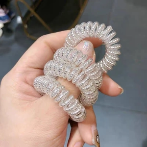 Dettaglio di un set di 3 elastici per capelli a spirale in TPU trasparente con perline argento