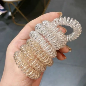 Dettaglio di elastici a spirale per capelli a filo del telefono con riflessi metallici