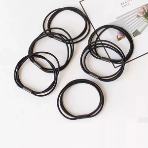 Detail of six high-elasticity braided black hair ties with reinforced plastic joints