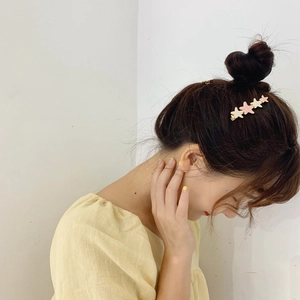 Minimalist cream and pink star hair clip for women on a white background