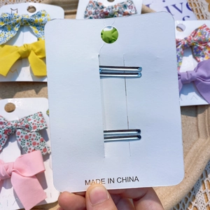 Vue arrière de barrettes à nœuds à carreaux avec clip en métal sur carte blanche