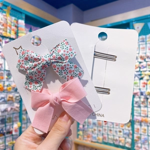 Détail de pinces à cheveux en tissu avec motif floral et couleur rose unie