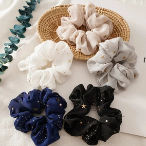 Five assorted colors of sweet chiffon star pattern hair scrunchies in a flat lay set