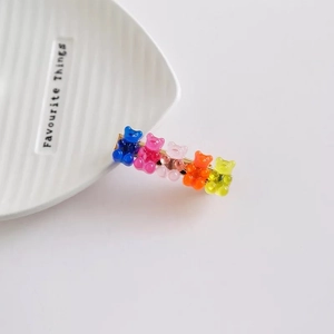 Détail de cinq pinces à cheveux en forme d'oursons colorés sur une assiette en céramique