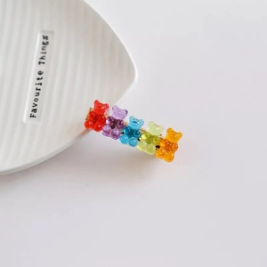 Détail de cinq pinces à cheveux oursons en résine colorée sur un support doré