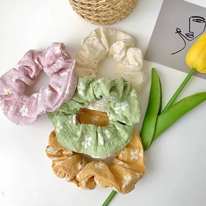 Floral scrunchie set with daisy prints in pastel colors on a white background