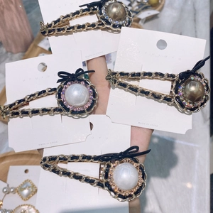 Retro hair clip featuring chain-woven leather, pearls, rhinestones, and black bows